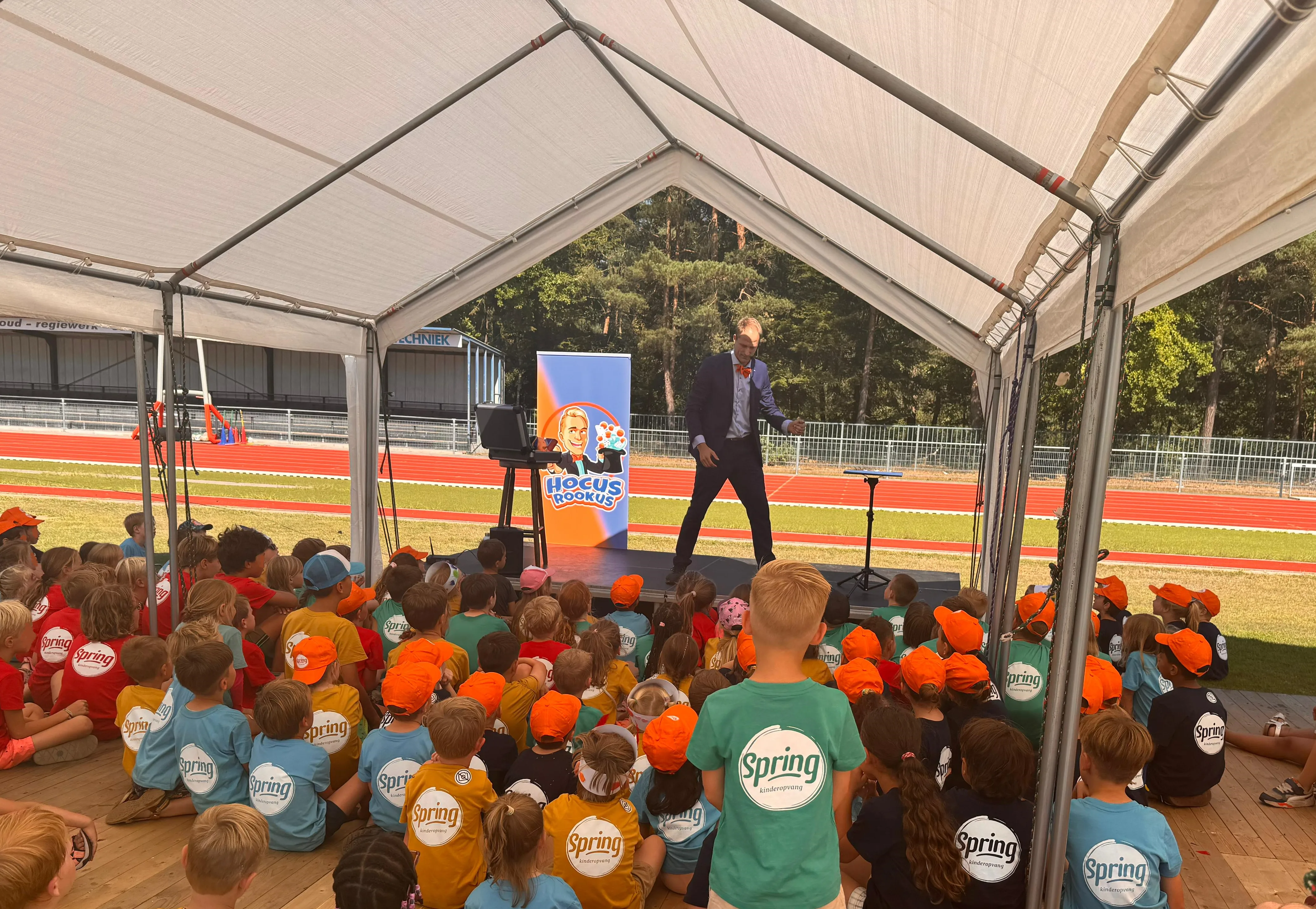 Kindergoochelaar Hocus Rookus op groot podium tijdens BSO Spring festival met honderden kinderen